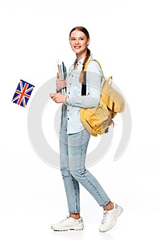 Smiling girl with backpack holding copybooks and uk flag