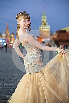 A smiling girl in a beautiful dress on Red Square