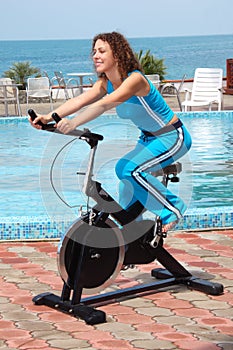 Smiling girl on bicycle training apparatus outdoor