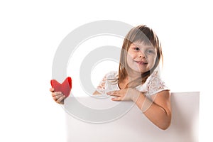 Smiling girl with a board for writing and a red heart in her han