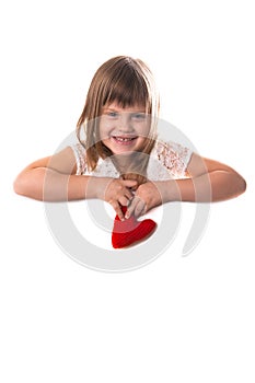 Smiling girl with a board for writing and a red heart in her han