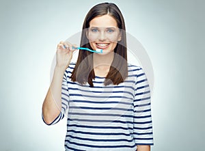 Smiling girl with brace brushing teeth.