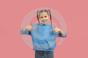 Smiling girl with braids pointing at herself