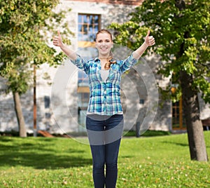 Smiling girl in casual clothes showing thumbs up