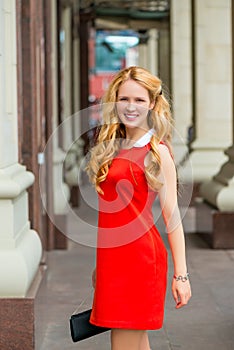 Smiling girl with chic curls in the city