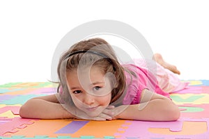 Smiling girl child resting on kids alphabet floor