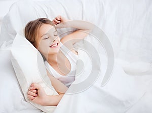 Smiling girl child waking up in bed at home photo
