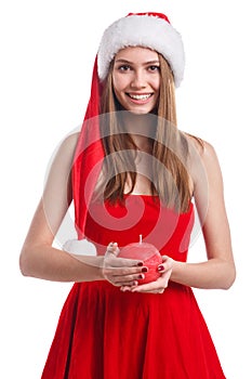 Smiling girl in Christmas dress and santa hat holding a candle in red and round shape. Isolated on white background.
