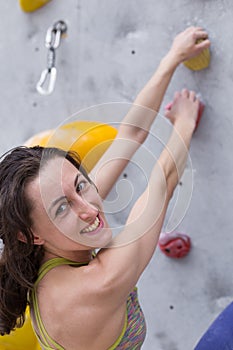 Smiling girl climbs the climbing wall