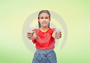 smiling girl comparing different light bulbs