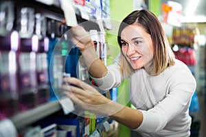 smiling girl customer looking for effective mouthwash in supermarket