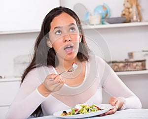 Smiling girl eating tasty sala