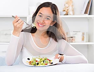 Smiling girl eating tasty sala
