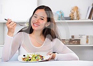 Smiling girl eating tasty sala