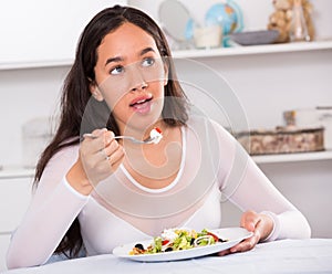 Smiling girl eating tasty sala