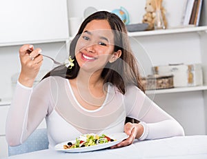 Smiling girl eating tasty sala