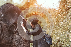 The smiling girl embraces an elephant.