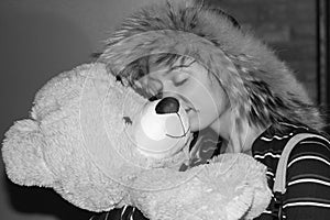 Smiling girl embracing bear shaped pelouche