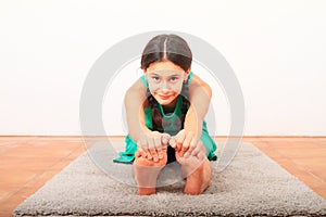 Smiling girl exercising yoga - seated forward fold