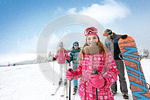Smiling girl with family on ski terrain