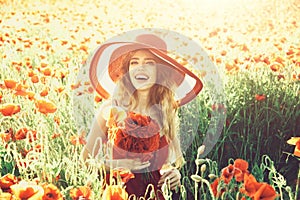 Smiling girl in field of poppy seed in retro hat