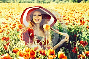 Smiling girl in field of poppy seed in retro hat