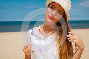 Smiling girl with flower on beach