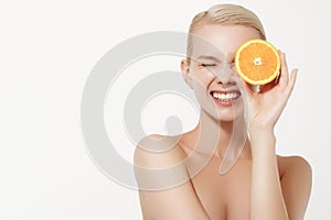 Smiling girl with fresh fruits. Beauty model takes juicy oranges. Joyful girl with freckles. The concept of a healthy