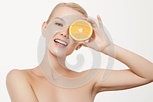 Smiling girl with fresh fruits. Beauty model takes juicy oranges. Joyful girl with freckles. The concept of a healthy