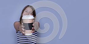 Smiling girl giving, showing coffeecup closeup side view