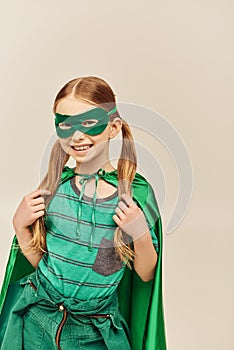 smiling girl in green superhero costume