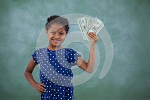 Smiling girl with hand on hip showing paper currency