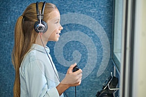 Smiling girl in headphones in the audiometric room photo