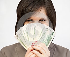 Smiling girl hiding behind a fan from dollars