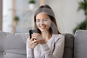 Smiling girl hold smartphone receive pleasant text message