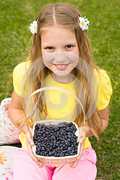 Smiling girl holding basket with berry