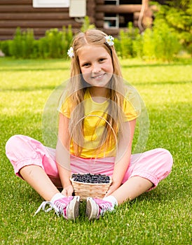 Smiling girl holding basket with berry