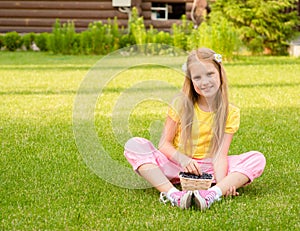 Smiling girl holding basket with berry