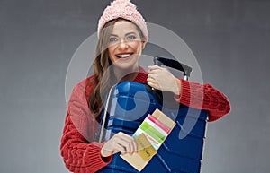 Smiling girl holding case and credit card, passport, ticket.