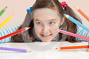 Smiling girl holding color pencils photo