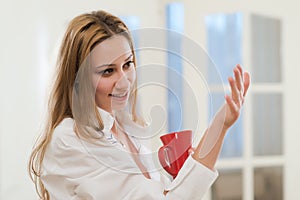 Smiling girl holding a cup of coffee or tea