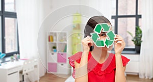 smiling girl holding green recycling sign