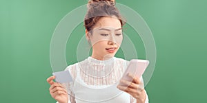 Smiling girl holding phone and credit card. Shopping online concept