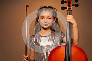 Smiling girl holding string to play violoncello
