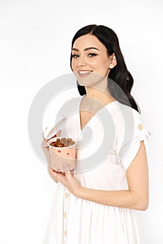 Smiling girl holds paper box with fruit pastille