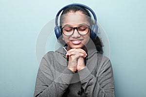 Smiling girl of Indian ethnicity listening music with her eyes closed