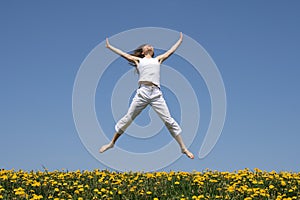 Smiling girl jumping in field