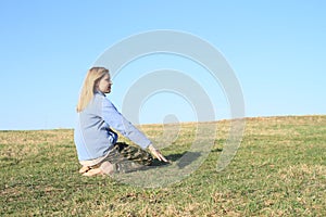 Smiling girl kneeling on meadow