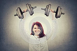 Smiling girl lifting dumbbell