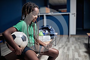 Smiling girl  listen music on phone in locker room